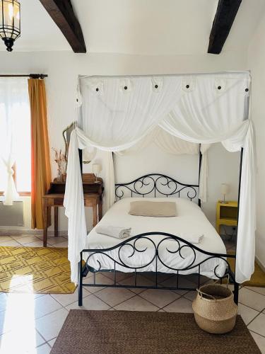 une chambre avec un lit à baldaquin dans l'établissement Les Copains à Bord, à Saint-Julien-dʼArpaon