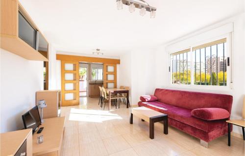 a living room with a red couch and a table at Pet Friendly Apartment in Oropesa del Mar