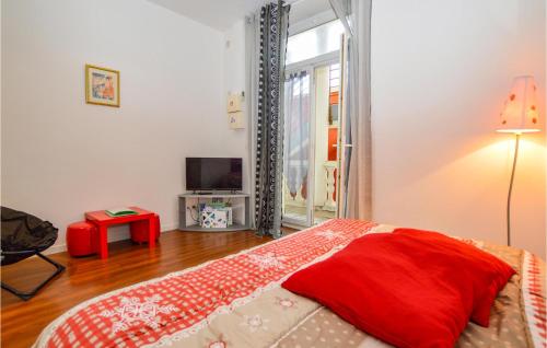 バスティアにあるLovely Apartment In Bastia With House A Mountain Viewのベッドルーム(赤い枕のベッド1台、テレビ付)