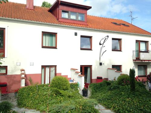 a white house with a red roof at Solrosen i Simrishamn - Österlen in Simrishamn