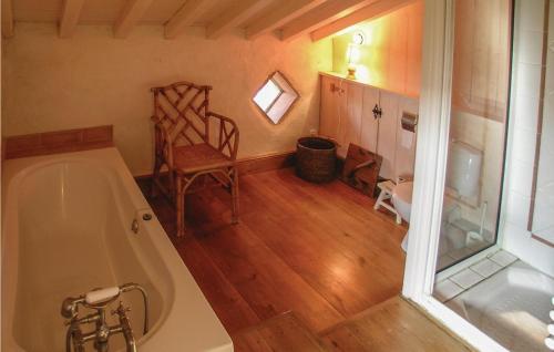 a bathroom with a bath tub and a wooden floor at Amazing Home In Beauville With 6 Bedrooms, Wifi And Outdoor Swimming Pool in Beauville