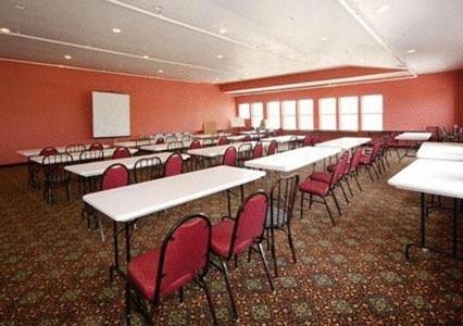 a classroom with tables and red chairs in a room at Crown Choice Inn & Suites Lakeview and Waterpark in Mackinaw City