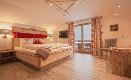 um quarto com uma cama grande e uma janela grande em Pension Alpenblick em Pfronten