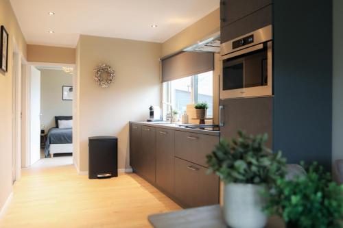 a kitchen with a sink and a stove top oven at Stijlvol ingerichte bungalow aan de Westerschelde in Baarland