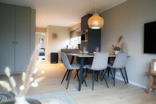 a kitchen and dining room with a table and chairs at Stijlvol ingerichte bungalow aan de Westerschelde in Baarland