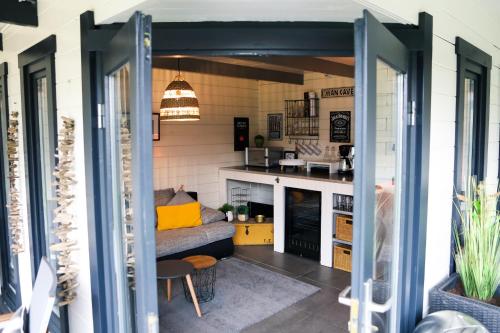 a living room with a couch and a kitchen at Stijlvol ingerichte bungalow aan de Westerschelde in Baarland