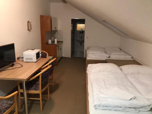 a room with two beds and a desk with a computer at FitApartman in Mitterfirmiansreut