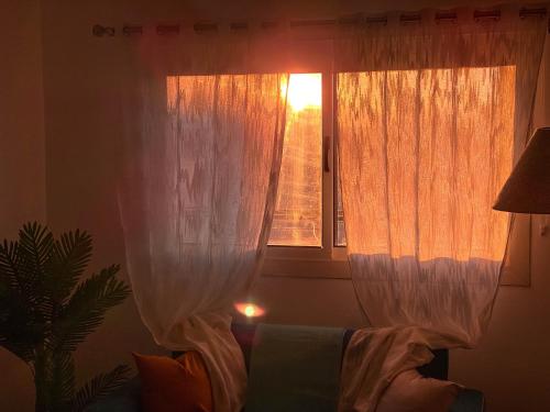 a window with curtains and a couch in a room at Modern Mountain View on The Touristic Promenade in Hurghada