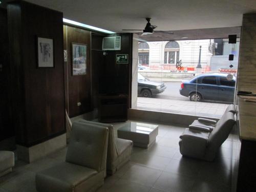 a living room with a couch and chairs and a window at Hotel Nahuel in Rosario