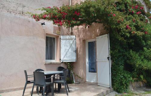 une table et des chaises devant un bâtiment fleuri dans l'établissement Cozy Apartment In Talasani, à Talasani