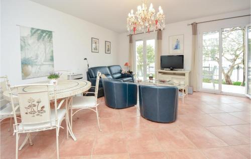 - un salon avec une table, des chaises et une télévision dans l'établissement 3 Bedroom Lovely Home In Aigues-Mortes, à Aigues-Mortes