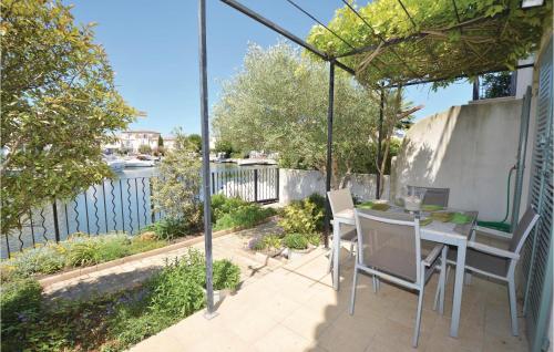 d'une terrasse avec une table et des chaises et une vue sur l'eau. dans l'établissement 3 Bedroom Lovely Home In Aigues-Mortes, à Aigues-Mortes