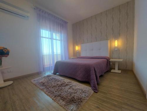 - une chambre avec un lit et une grande fenêtre dans l'établissement Hotel Il Gabbiano Beach, à Terme Vigliatore
