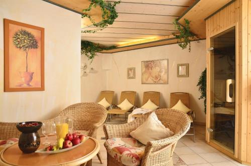 a room with chairs and a table with a bowl of fruit at Landhaus am Rosenbächle in Pfronten