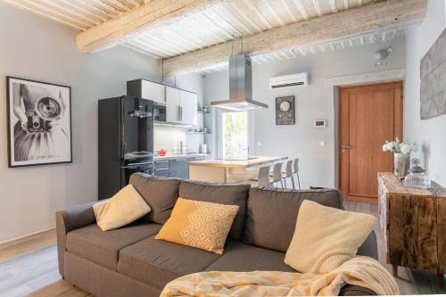a living room with a couch and a kitchen at appartement de charme dans le luberon in Lagnes