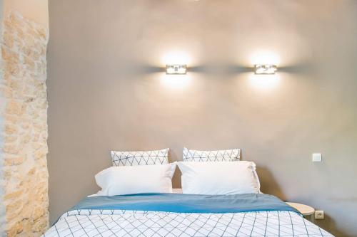 a bedroom with a bed and two lights on the wall at appartement de charme dans le luberon in Lagnes