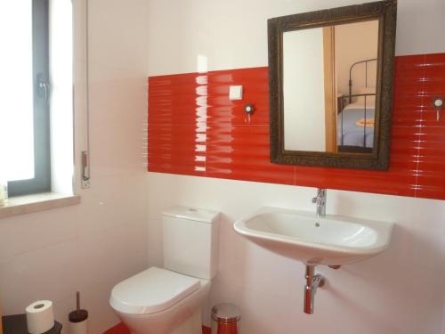 a bathroom with a toilet and a sink and a mirror at Suite na Casa da Andreia in São Martinho do Porto