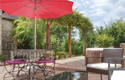 patio con tavolo, sedie e ombrellone rosso di Cozy Home In Preuilly Sur Claise a Preuilly-sur-Claise