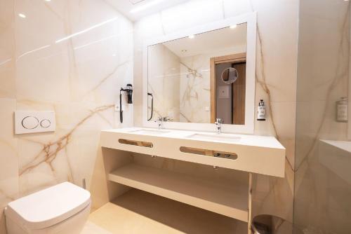 a bathroom with a sink and a toilet and a mirror at Hotel Gold Arcos 4 Sup - Built in May 2022 in Benidorm