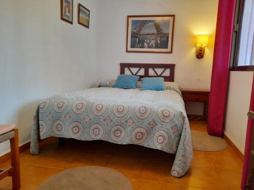 a bedroom with a bed with blue pillows on it at Apartamento cerca del mar in Matalascañas
