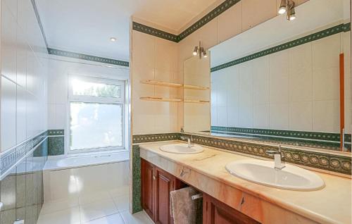 een badkamer met 2 wastafels en een grote spiegel bij Beautiful Home In Santa Susanna With Wifi, Outdoor Swimming Pool And Heated Swimming Pool in Santa Susanna