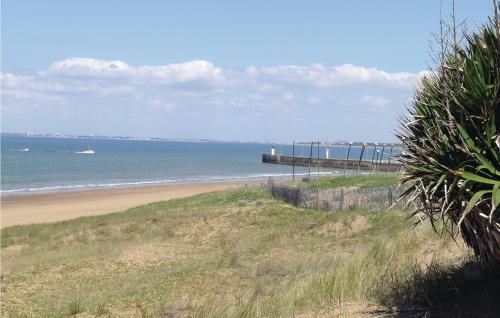 - une plage avec une jetée et un bateau dans l'eau dans l'établissement Two-Bedroom Holiday Home In St Michel Chef Chef, à Saint-Michel-Chef-Chef