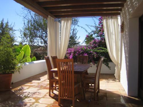 uma mesa e cadeiras num pátio com flores em Morna valley em Sant Carles de Peralta