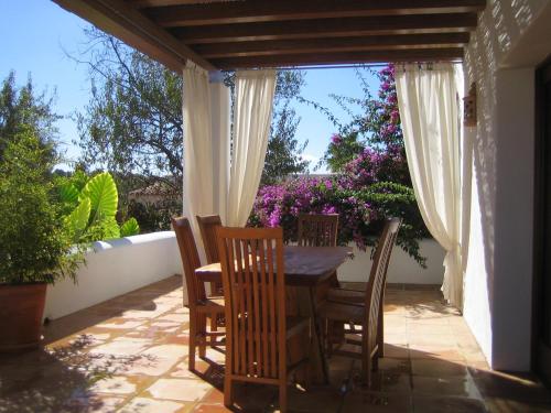 una mesa y sillas en un patio con flores en Morna valley, en Sant Carles de Peralta