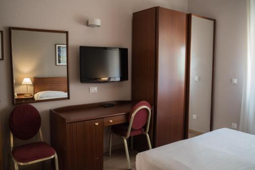 Cette chambre dispose d'un bureau et d'une télévision murale. dans l'établissement Hotel Mediterraneo, à Palerme
