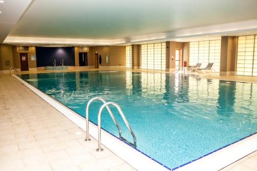 uma grande piscina interior com água azul em East Sussex National Hotel, Golf Resort & Spa em Uckfield