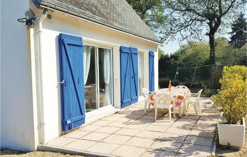 Riec-sur-BélonにあるHoliday Home Riec Sur Belon 3の青いドア、テーブルと椅子付きのパティオ