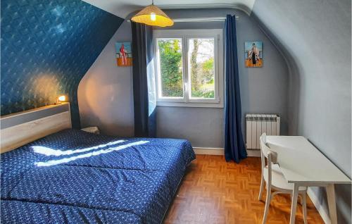 een slaapkamer met een blauw bed en een raam bij 3 Bedroom Awesome Home In Riec Sur Belon in Riec-sur-Bélon