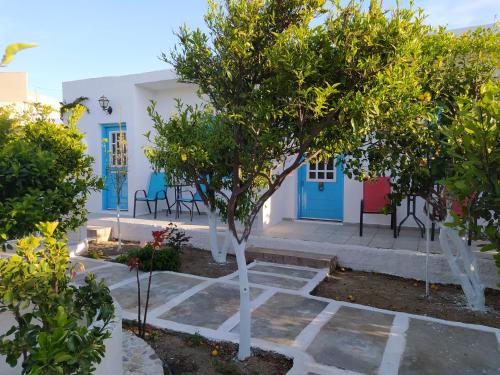 a house with blue doors and trees in front of it at Perivoli 3-Chora(5min away from the center by car) in Agkidia