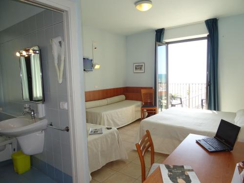 Pokój hotelowy z sypialnią z łóżkiem i umywalką w obiekcie Hotel Sole E Mare w mieście Lido di Camaiore