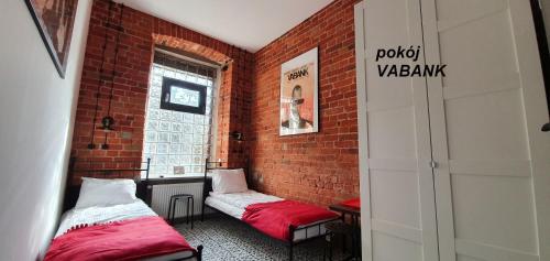 Pokój z 2 łóżkami i ceglaną ścianą w obiekcie Cosy Rooms w Piotrkowie Trybunalskim