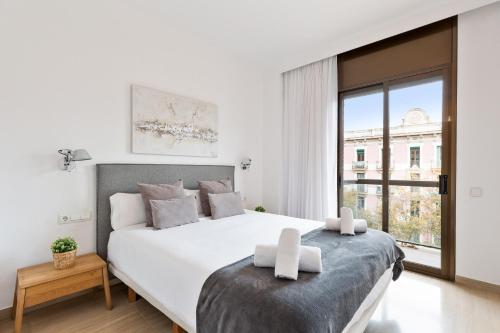 Un dormitorio blanco con una cama grande y una ventana en Stay U-nique Apartments Sant Antoni II, en Barcelona