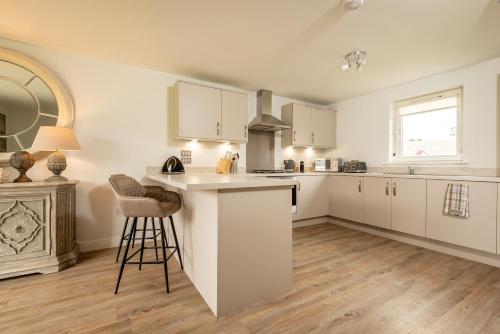 a kitchen with white cabinets and a counter top at Kingsbarns Village Green - Walk to Beach - Parking in Kingsbarns