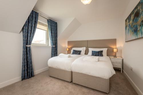 Un dormitorio con una cama grande y una ventana en Kingsbarns Village Green - Walk to Beach - Parking, en Kingsbarns