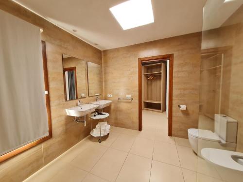 a bathroom with two sinks and a toilet at Morna valley in Sant Carles de Peralta