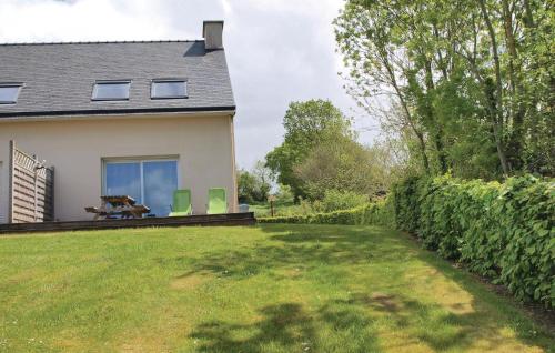 a house with a yard with two chairs and a table at Awesome Home In Plestin Les Greves in Plestin-les-Grèves