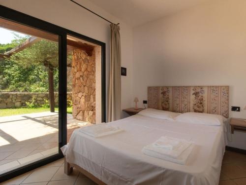 a bedroom with a bed and a sliding glass door at Baia Del Faro in Palau