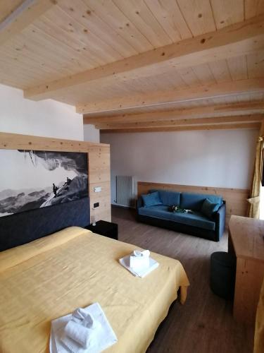 a large room with a bed and a couch at Hotel Vael in Vigo di Fassa
