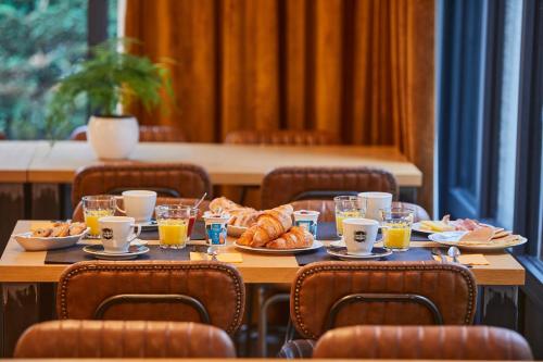 a table with plates of food and glasses of orange juice at La Flambée in Sennecey-lès-Dijon