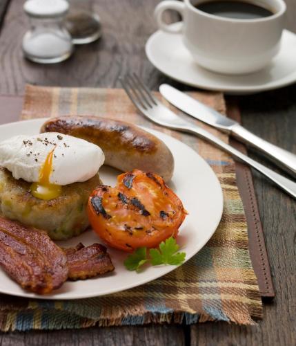 アックフィールドにあるイースト サセックス ナショナル ホテル， ゴルフ リゾート＆スパの卵とベーコンの料理とコーヒー一杯