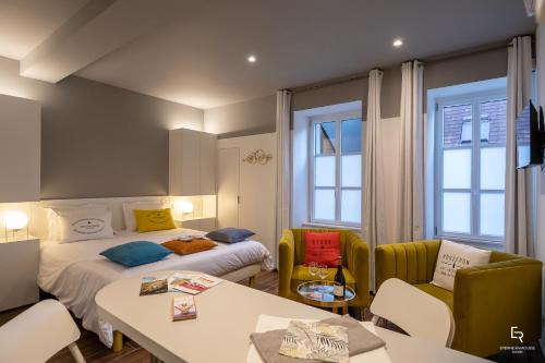 een hotelkamer met 2 bedden en een tafel en stoelen bij Activinum in Givry