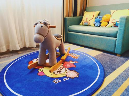 a toy horse on a blue rug in a living room at Holiday Inn Express Shanghai Zhenping by IHG in Shanghai