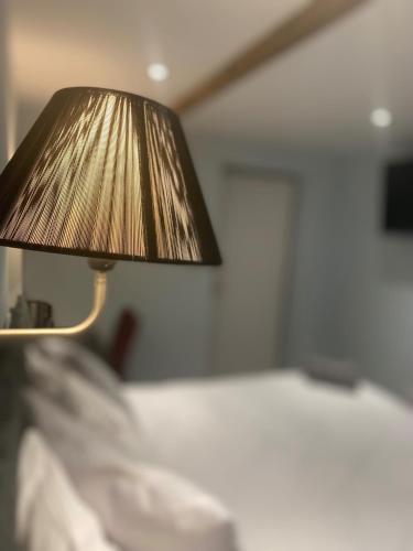 un primer plano de una lámpara en un dormitorio con cama en Comus Inn en Selby