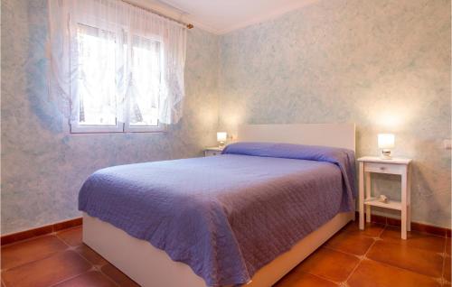 een slaapkamer met een bed, een raam en 2 tafels bij Lovely Home In Dnia With Kitchen in Denia