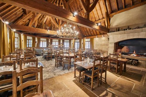 un restaurant avec des tables, des chaises et une cheminée dans l'établissement La Flambée, à Sennecey-lès-Dijon