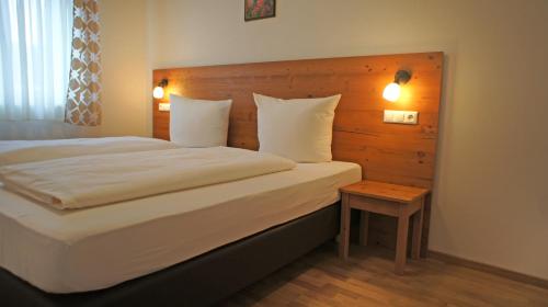 a bedroom with a large bed with a wooden headboard at Hotel Heimfeld Restaurant Cafe in Garching an der Alz